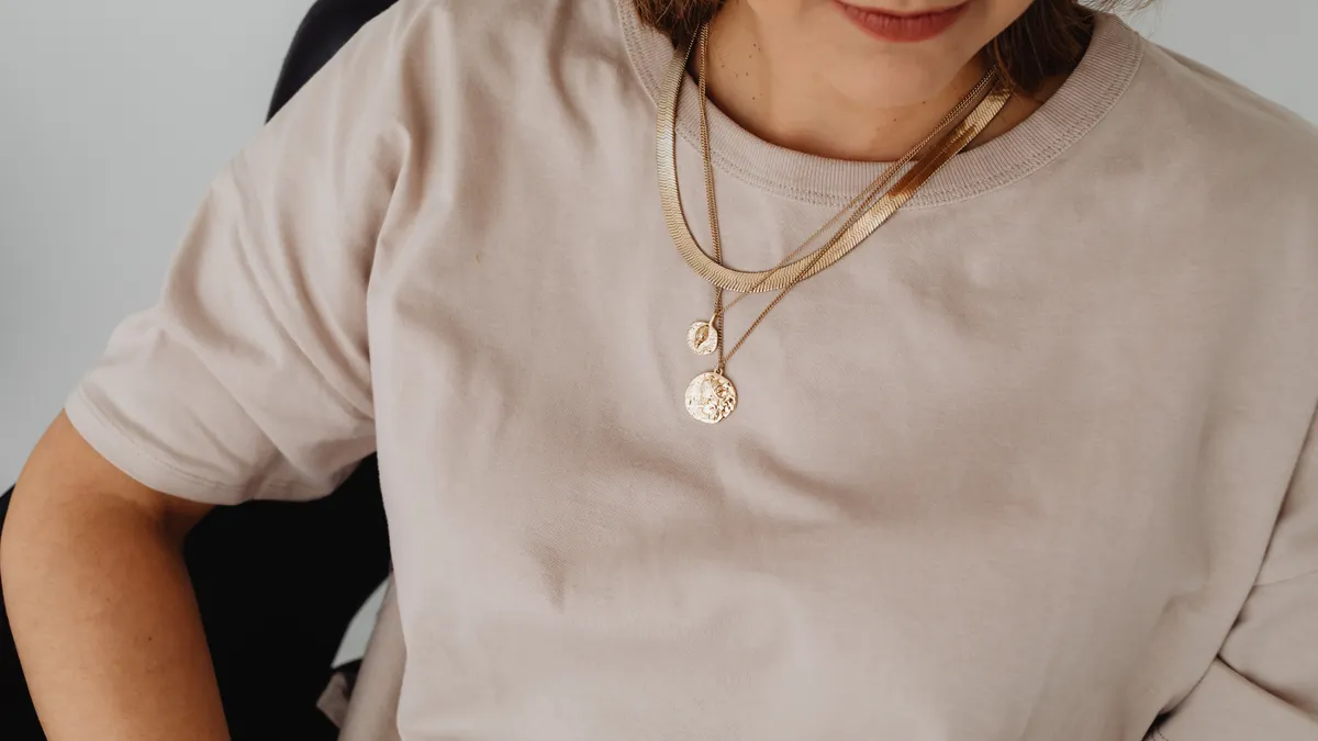 Person wearing two layered necklaces