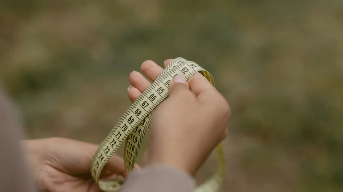 Hands looping a measuring tape