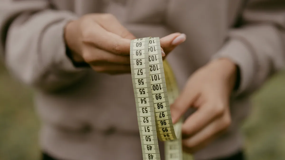 Person holding a measuring tape