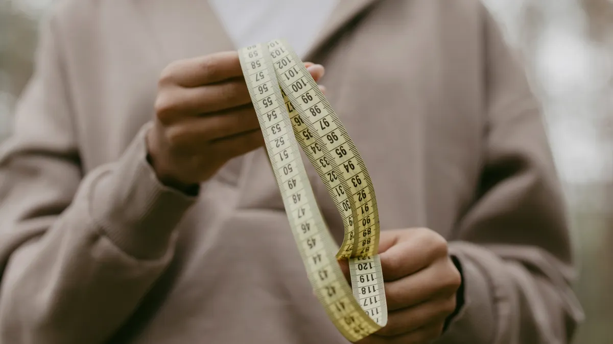Hands holding a flexible measuring tape