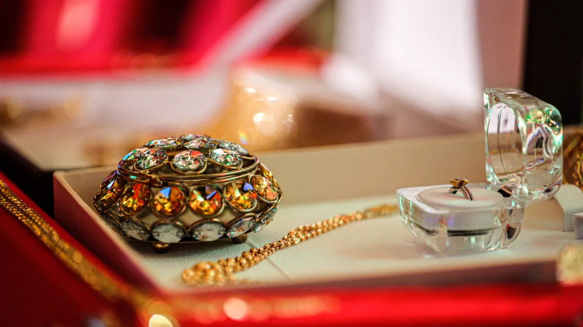 Initial pendant necklaces: how to choose a letter pendant that feels personal Jewelry box with a chain necklace nearby