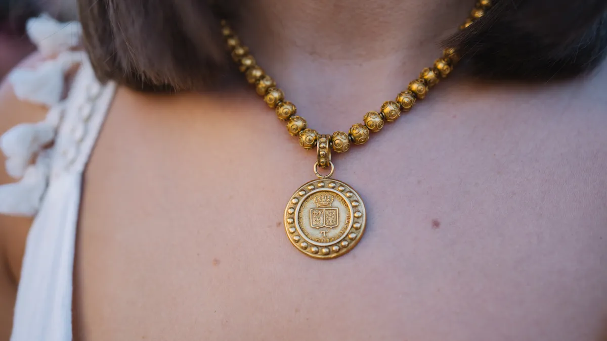 Necklace pendants and pendant styles — The Complete Guide Gold medallion pendant necklace worn on a person